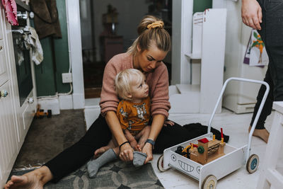 Mother helping toddler to get dressed