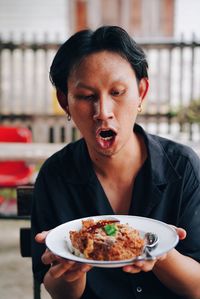 Portrait of man holding ice cream in restaurant