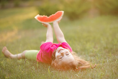Rear view of young woman doing yoga on field