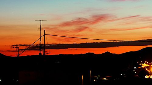 Silhouette of electricity pylon at sunset