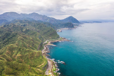 High angle view of sea and mountains against sky