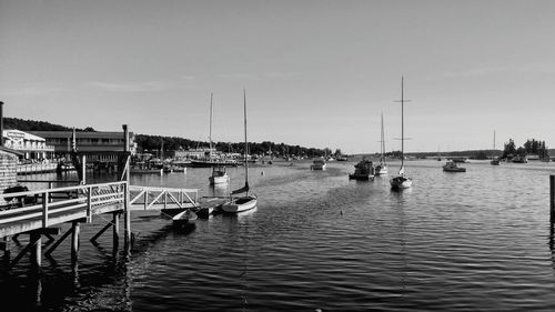 Boats moored at harbor against sky