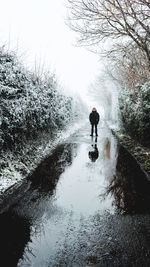 Man riding bicycle on snow covered land