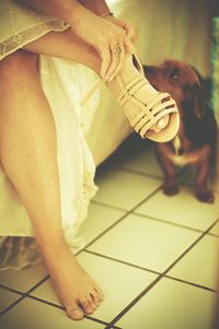 Low section of woman wearing sandals sitting over floor