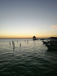 Silhouette boats in sea against clear sky
