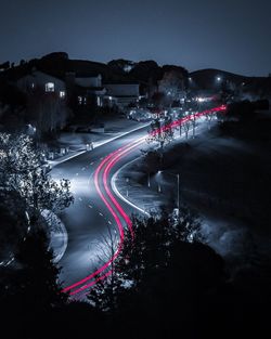 Light trails on road against sky at night