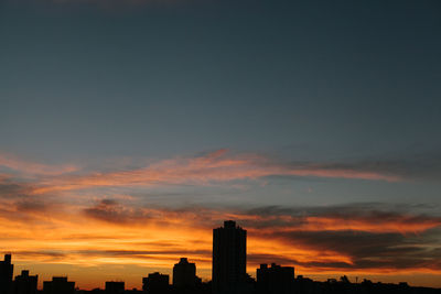 Silhouette cityscape against sky during sunset