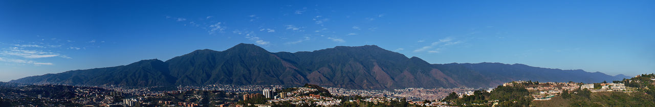 Panoramic view of mountains against blue sky