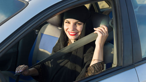 Portrait of smiling woman sitting in car