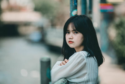 Portrait of young woman looking away outdoors