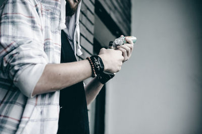 Midsection of man holding bottle