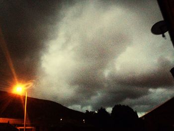 Low angle view of street light against cloudy sky