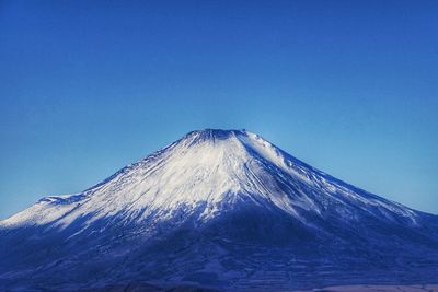 Scenic view of snowcapped mountain against blue sky