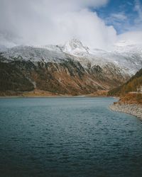 Scenic view of lake and snowcapped mountains against sky