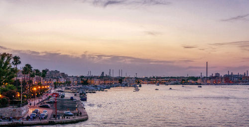 Sailboats in city at sunset