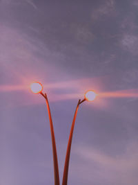 Low angle view of illuminated street light against sky during sunset