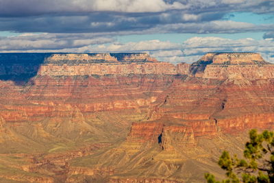 Rock formations on landscape against cloudy sky