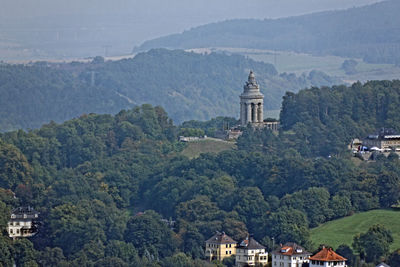 Church amidst trees and buildings against mountains