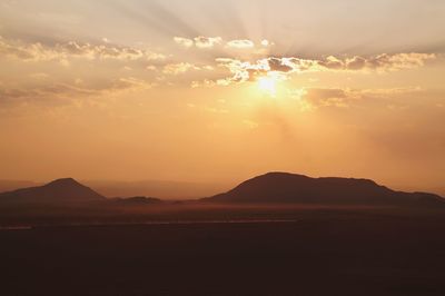 Scenic view of silhouette mountains against sky during sunset