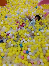 High angle view of woman playing with yellow petals