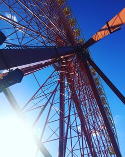 Low angle view of ferris wheel against blue sky
