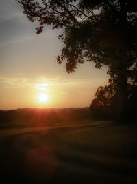 Scenic view of silhouette field against sky during sunset