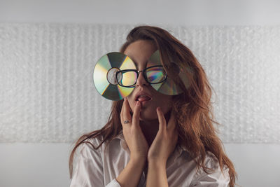 Woman wearing eyeglasses with compact discs