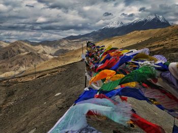 Multi colored flags on mountain against sky