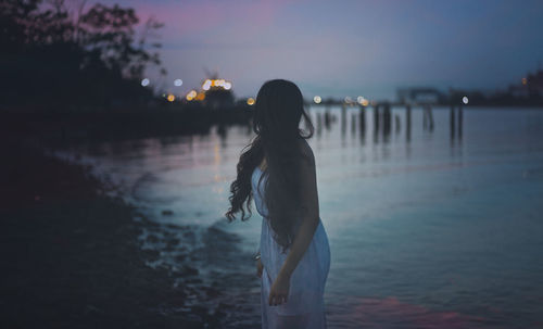Rear view of woman looking at sea against sky