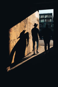 Rear view of silhouette people walking on building