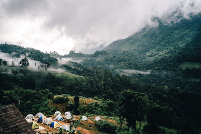 Scenic view of tents on mountains against sky