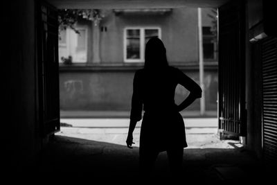 Rear view of silhouette woman standing in building