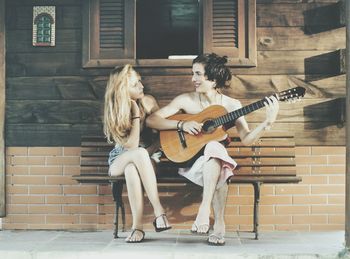 Boy playing guitar with girl