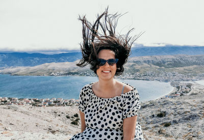 Portrait of young woman, wind blowing in her hair, funny, summer.