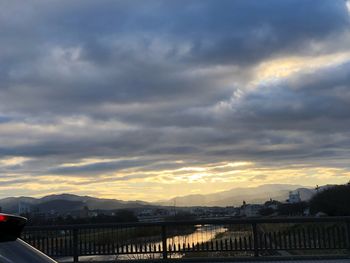 Bridge over river against sky during sunset