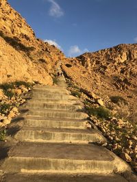 Staircase leading towards mountain against sky