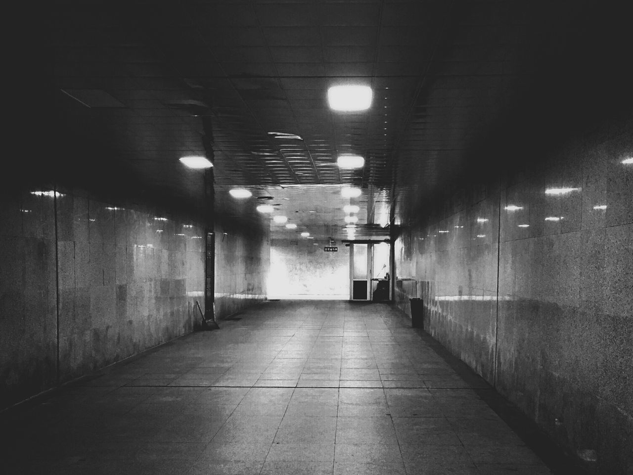 EMPTY CORRIDOR IN ILLUMINATED BUILDING