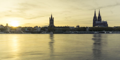View of buildings at waterfront during sunset
