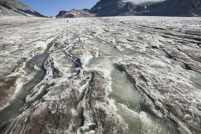 Man hikes on melting snowbird glacier, talkeetna mountains, alaska