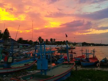 Boats moored at harbor during sunset