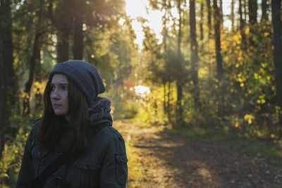 Side view of woman looking away in forest