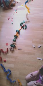 Midsection of girl playing with toys on hardwood floor