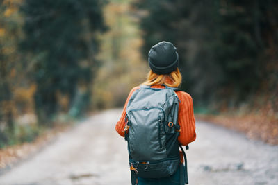 Rear view of man walking on road