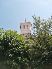 Low angle view of trees and building against sky