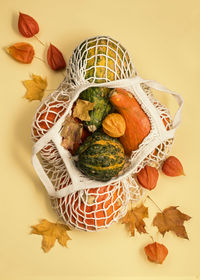 Autumn background with pumpkins in a string bag