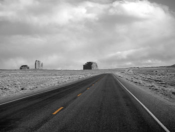 Empty road against cloudy sky