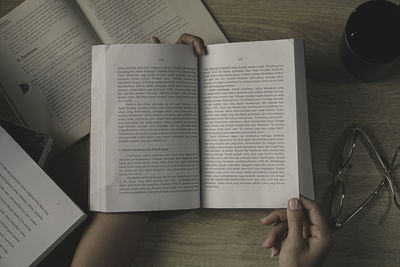 Cropped hands of man writing in book