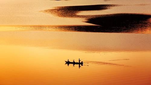 Silhouette ship on sea against sky during sunset