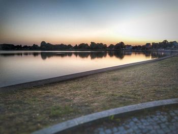 Scenic view of lake against clear sky during sunset