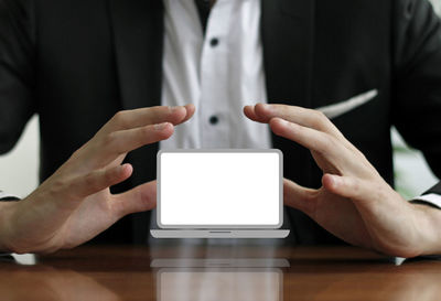 Midsection of man using mobile phone